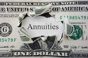 hole torn in a dollar bill with annuities text
