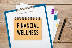 financial wellness is written on a notepad on an office desk