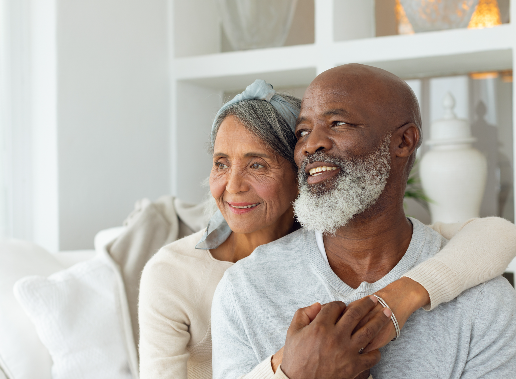 older couple happily hugging in their home