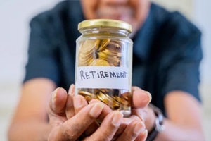 elderly man hand showing a jar full of coins