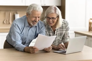 happy satisfied senior retired couple reading legal document