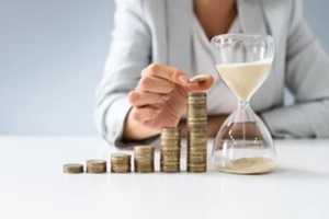 businesswoman with hourglass and stack of coins