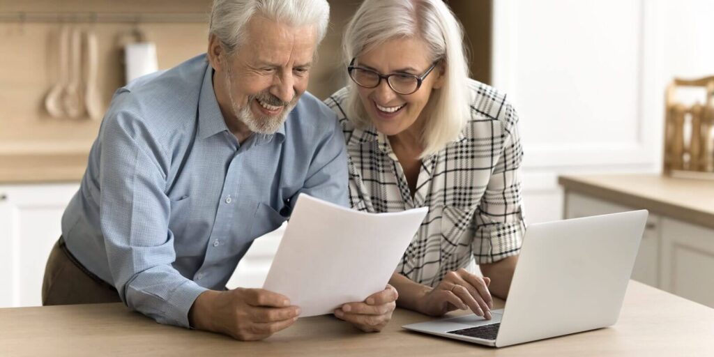 happy satisfied senior retired couple reading legal document, financial report