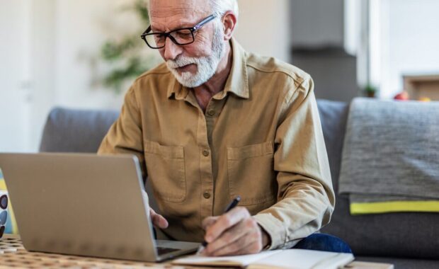 senior man working with financial papers at home